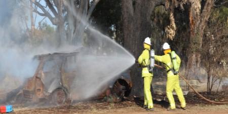 Two workers hosing vehicle