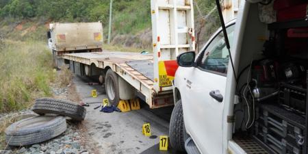 accident scene showing light vehicle that has collided into the rear of a truck trailer 